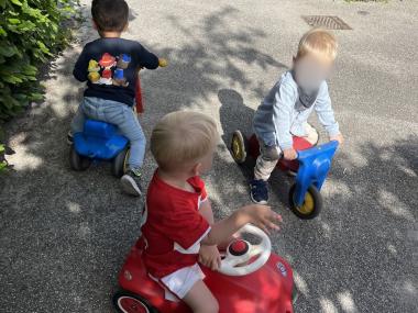 Børn der leger og kører på scooter 